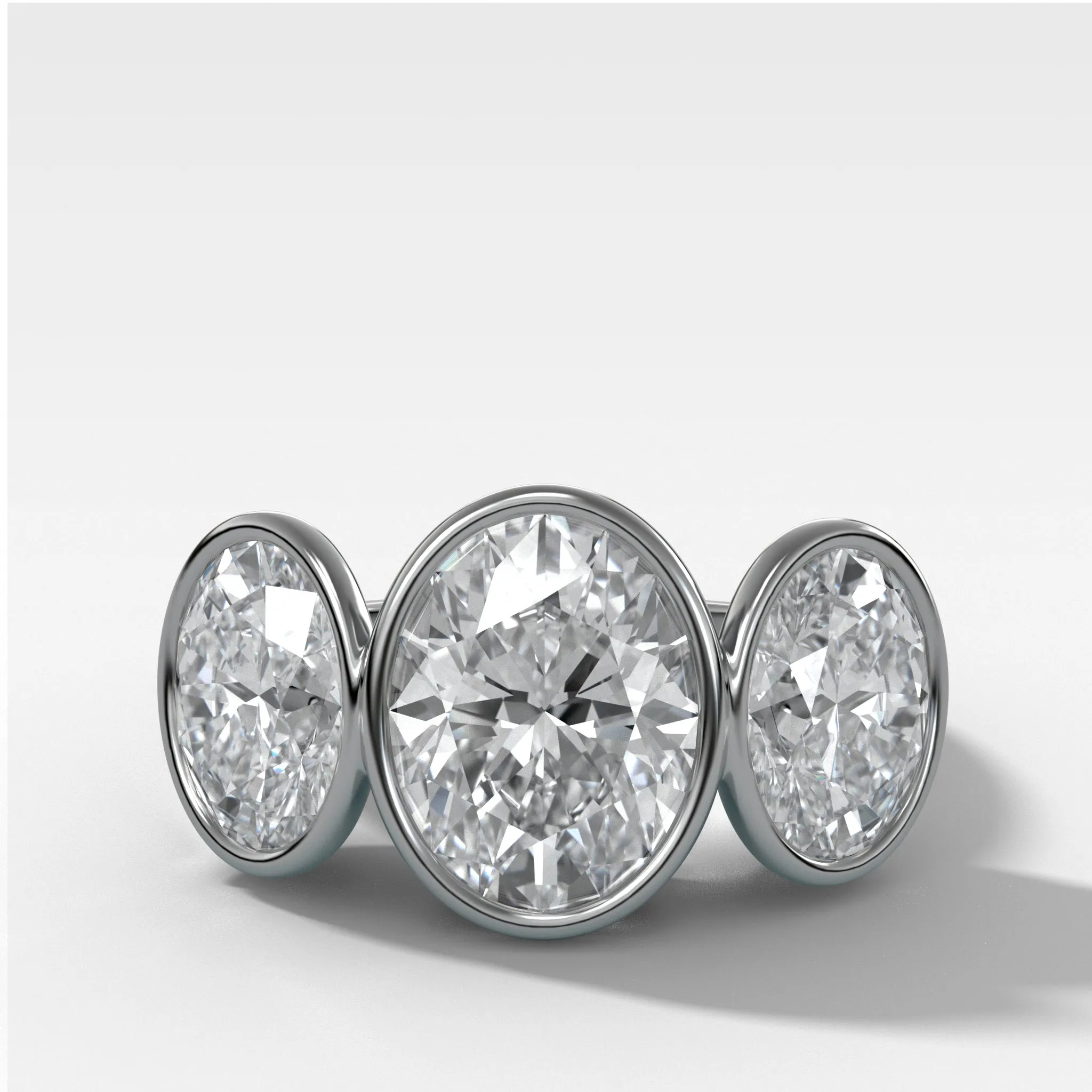 Penumbra Bezel Triad Engagement Ring With Oval Cut Diamonds
